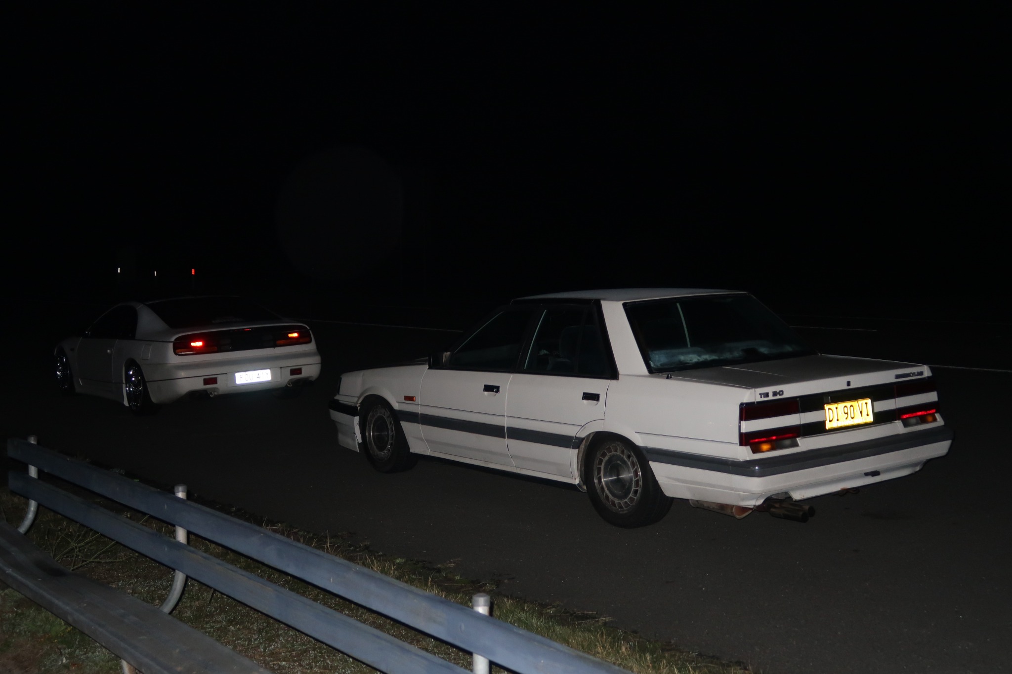 Two Nissan cars at night
